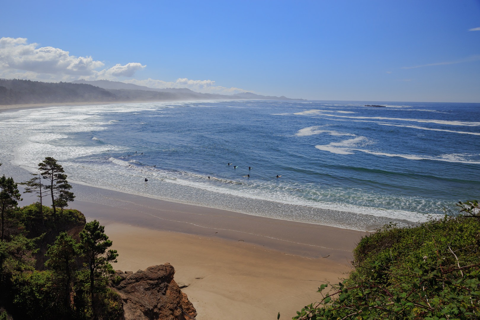 Surfers below the bluff at Devils Punchbowl State Natural Area.