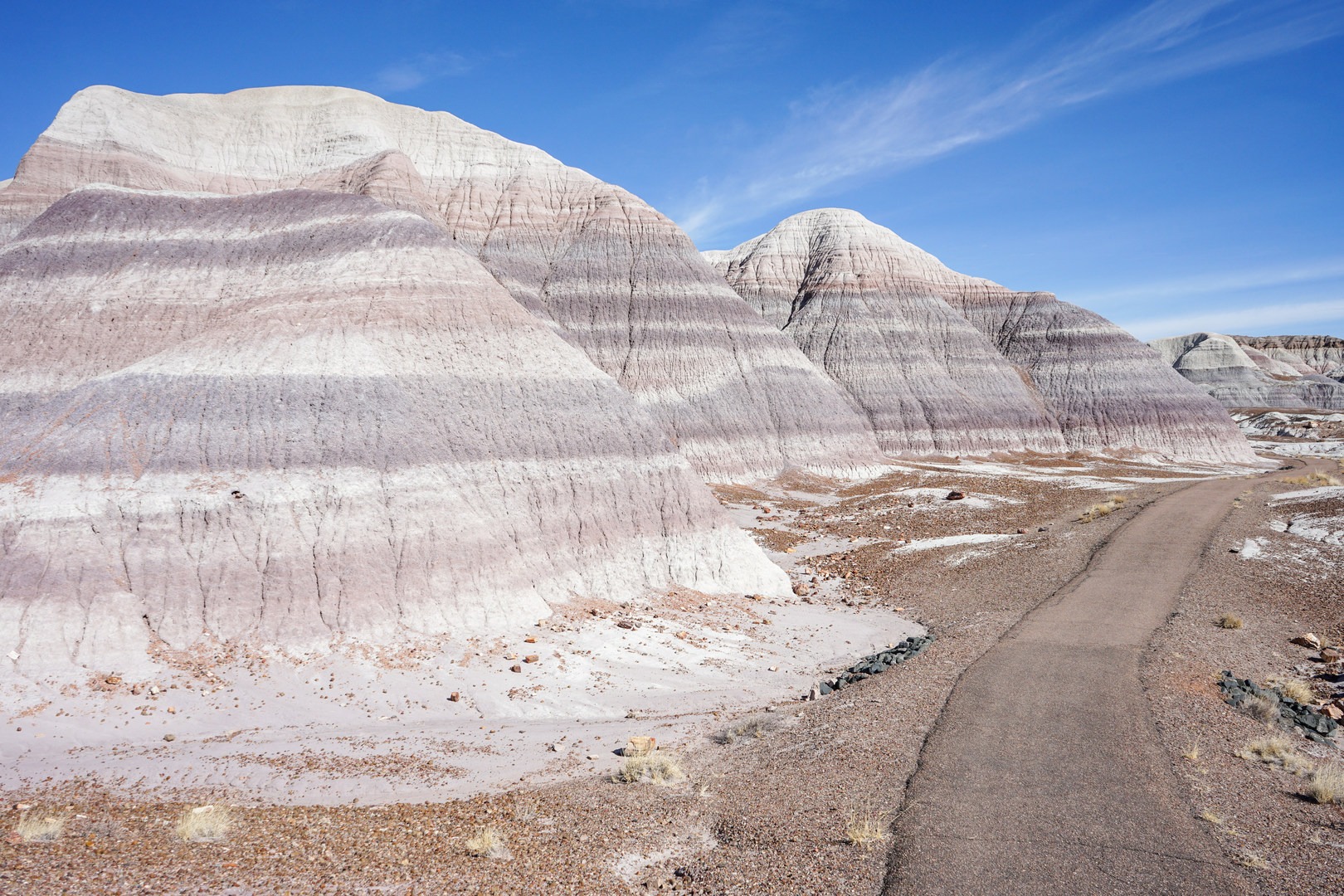 Blue badlands beneath blue sky.
