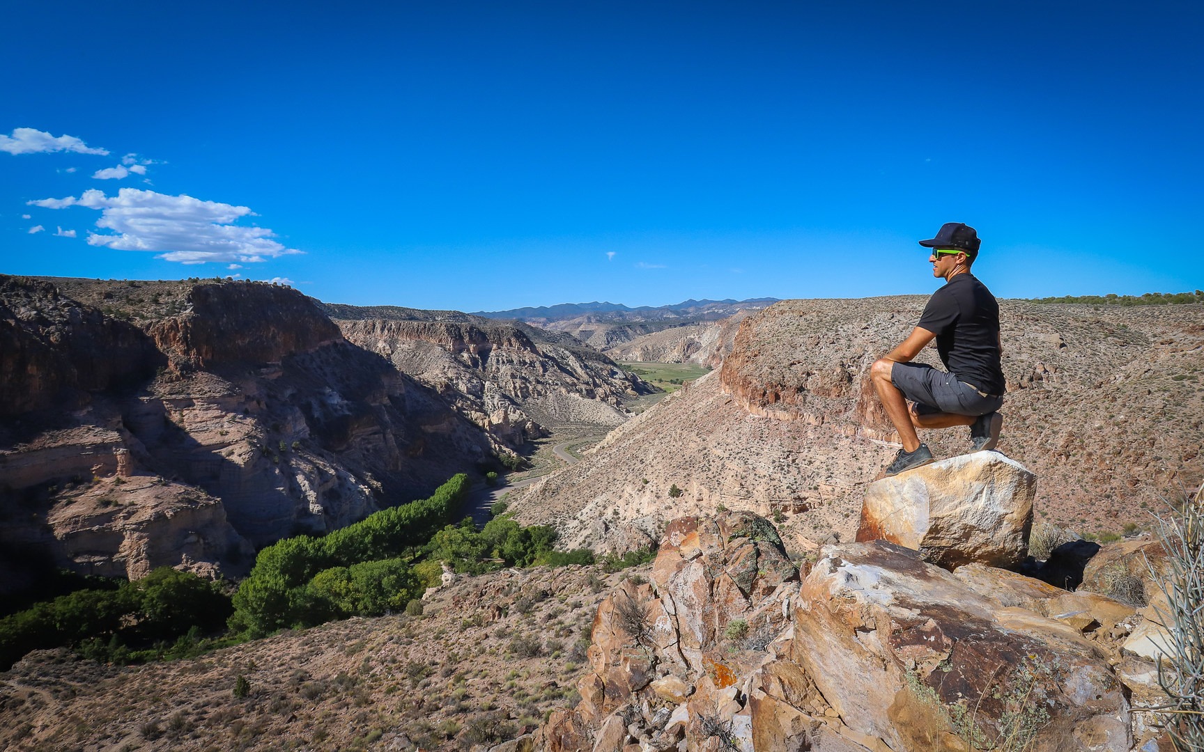 The trail peaks at a point overlooking the lush green canyon oasis below.