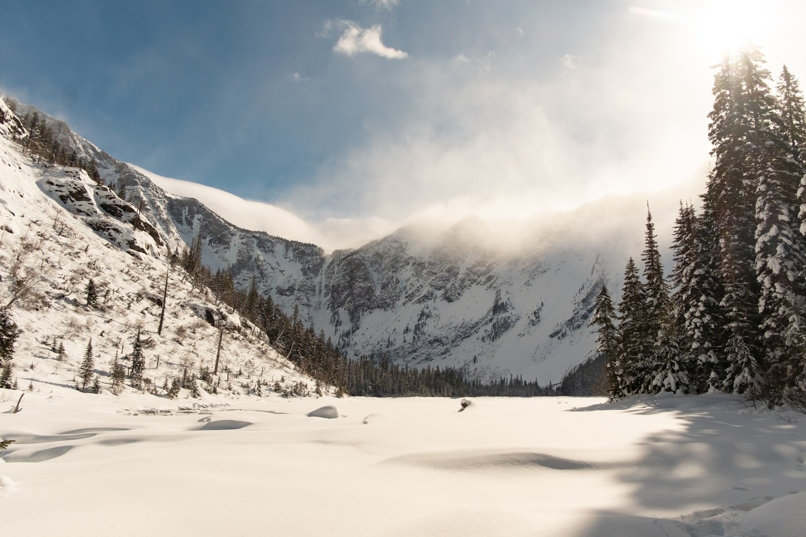 Wide open views over a frozen and snow-covered Avalanche Lake.