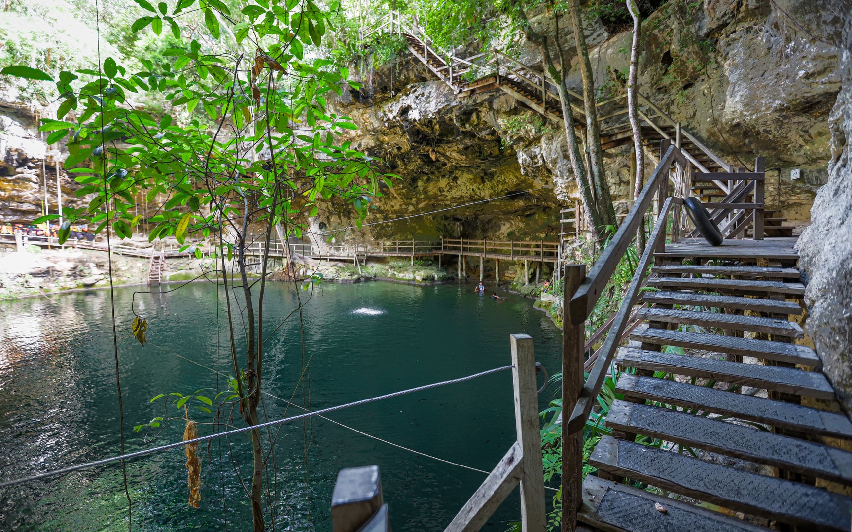 Stairs descend into the cenote.