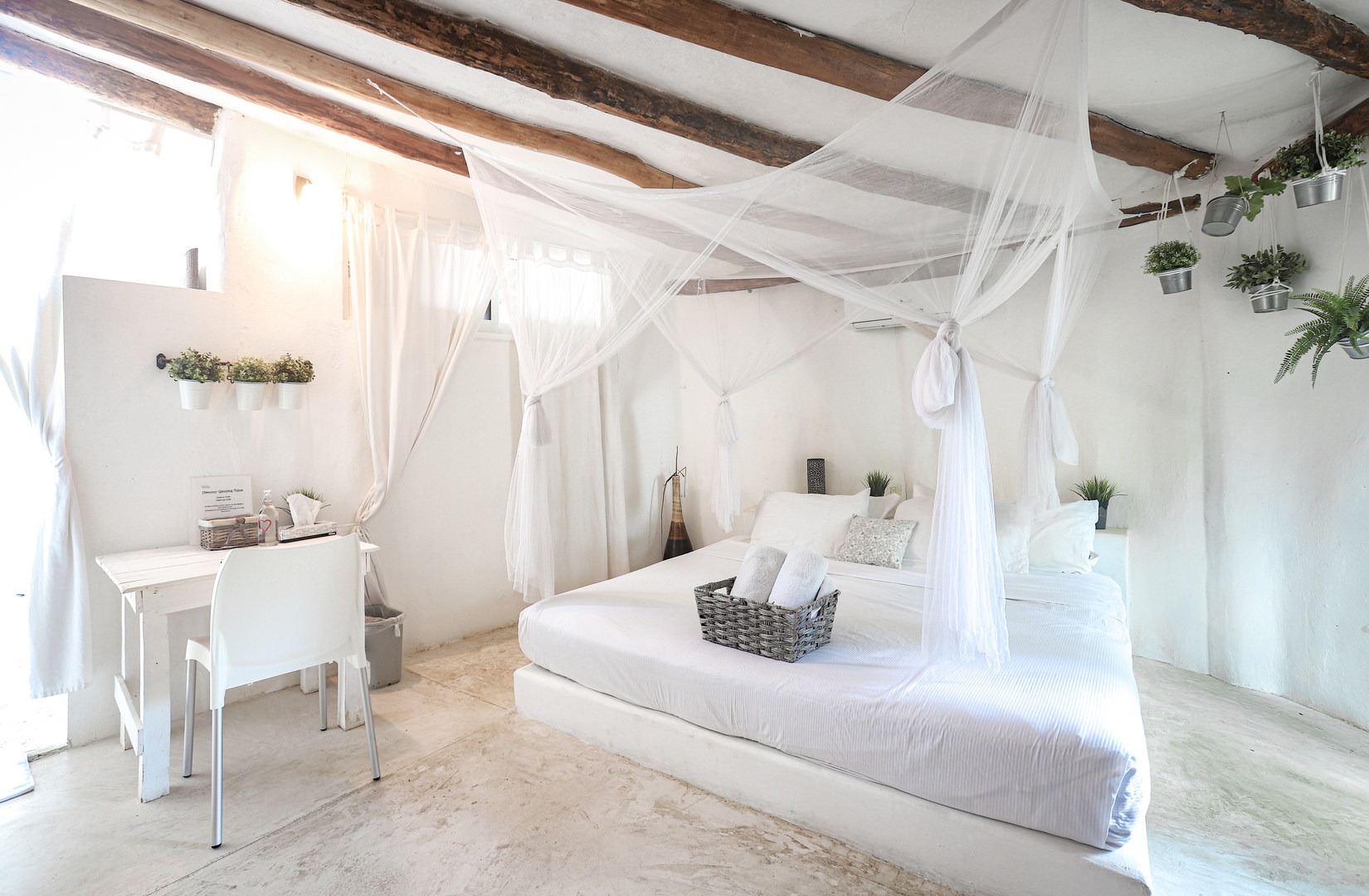 The bedroom of the Toscana Suite offers a clean modern room with king-size bed, air conditioning unit, and bathroom.