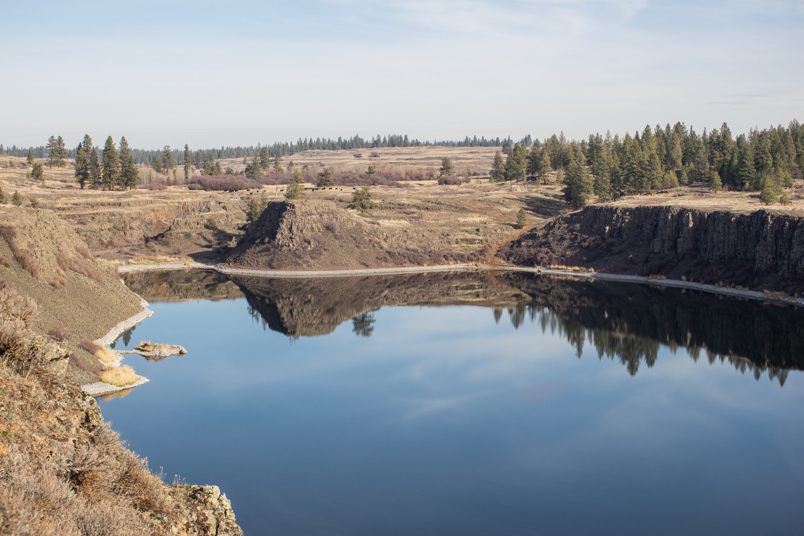 The south side of Hog Lake with a clear sky's reflection on it's surface.