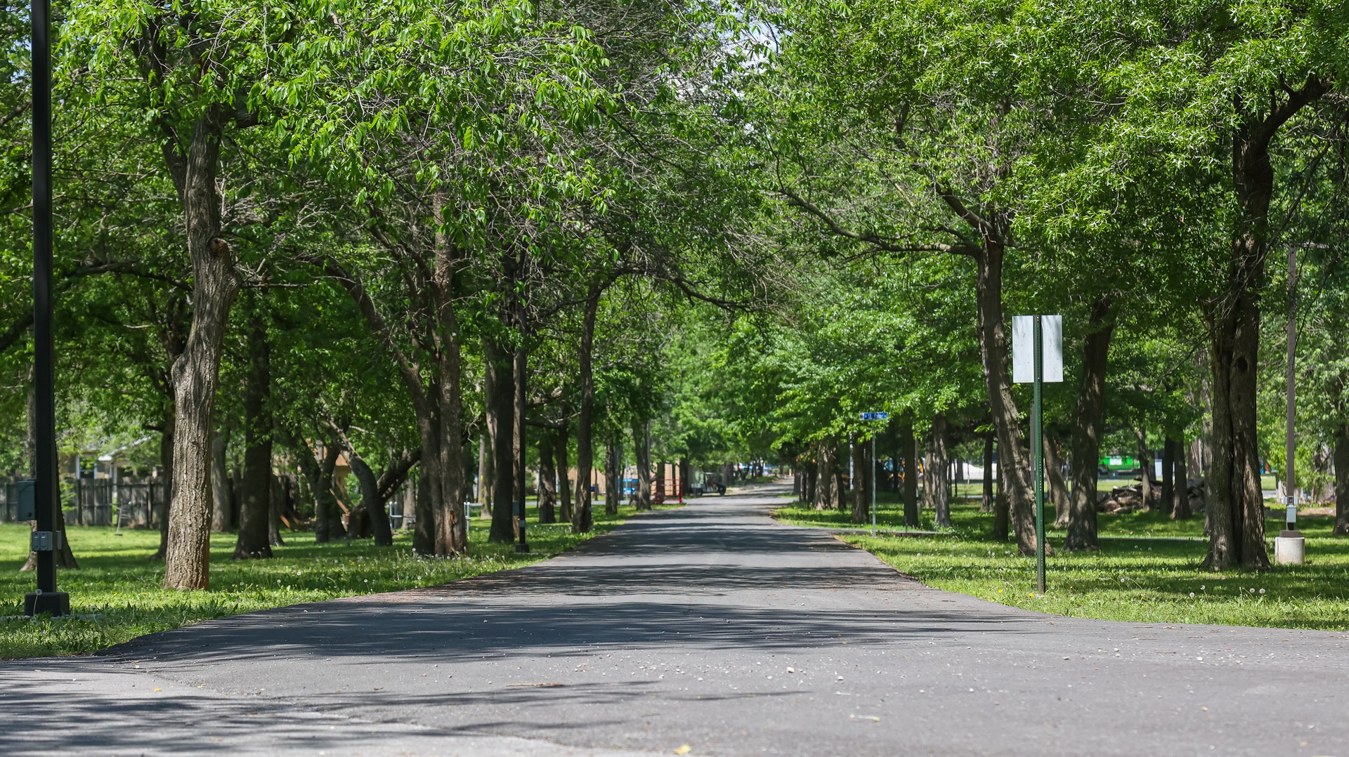 Wide shaded fields and walking paths within the park grounds.