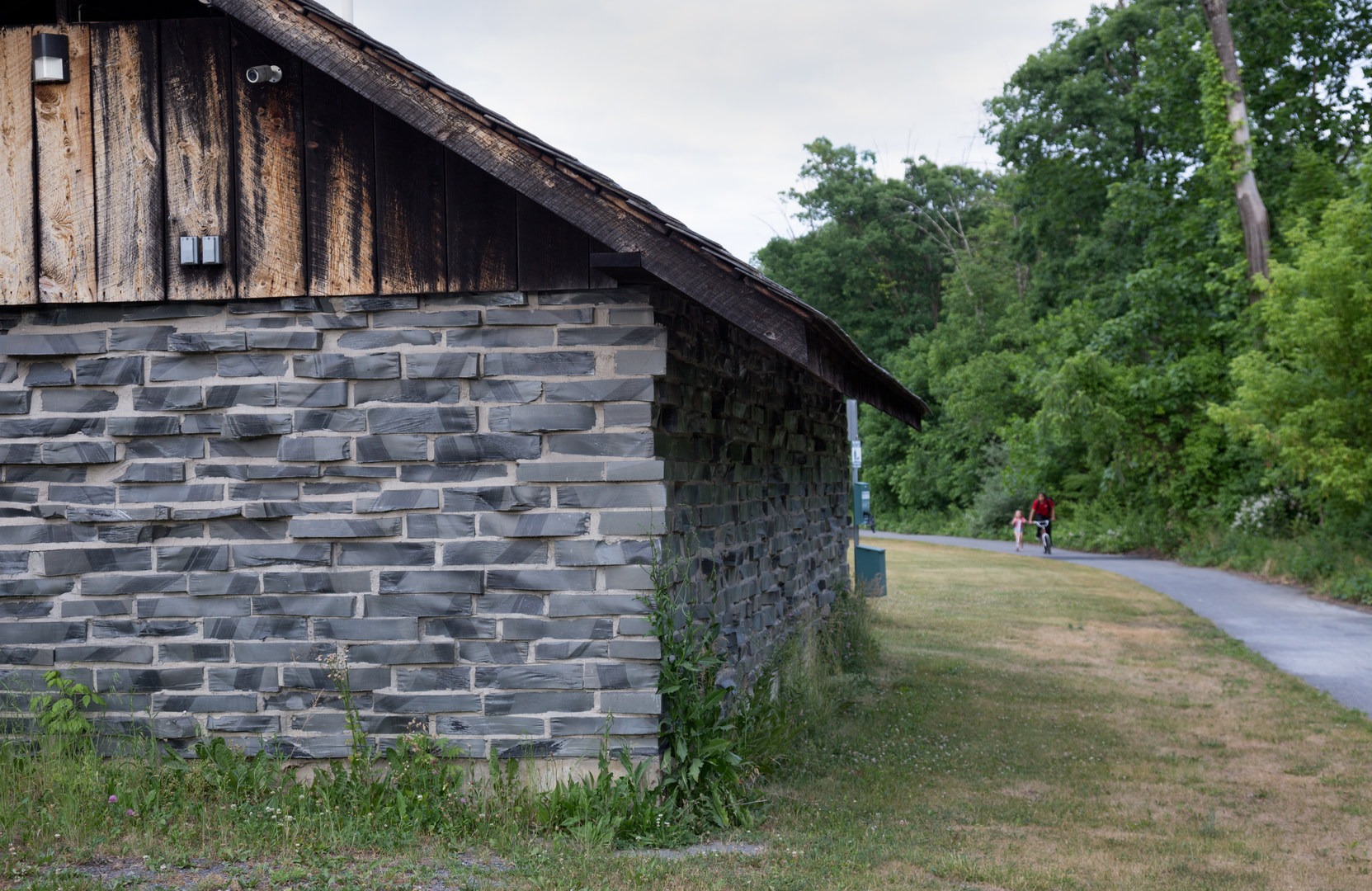 A restroom made from slate is alongside the trail.