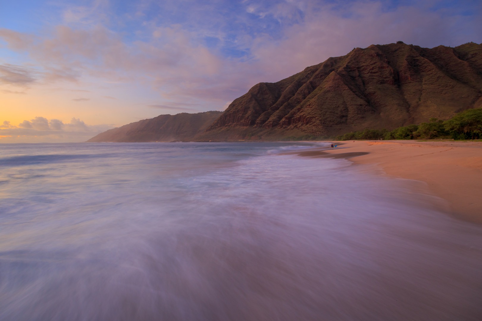Warm hues envelop the area in a glow as a vibrant sunset ends the day over Makua Beach.