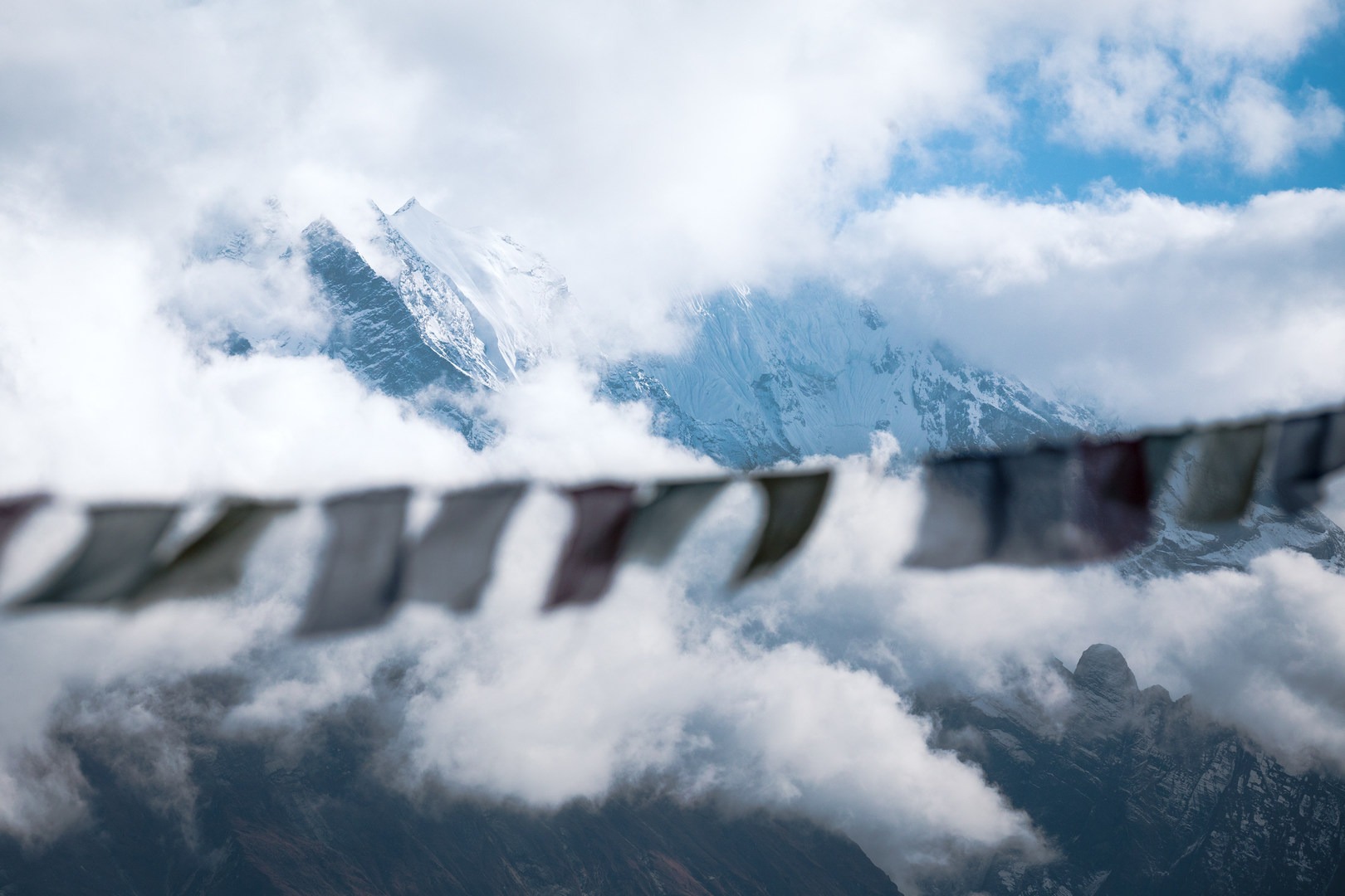 Prayer flags blow in the breeze overlooking the mountains atop Mu Gompa.